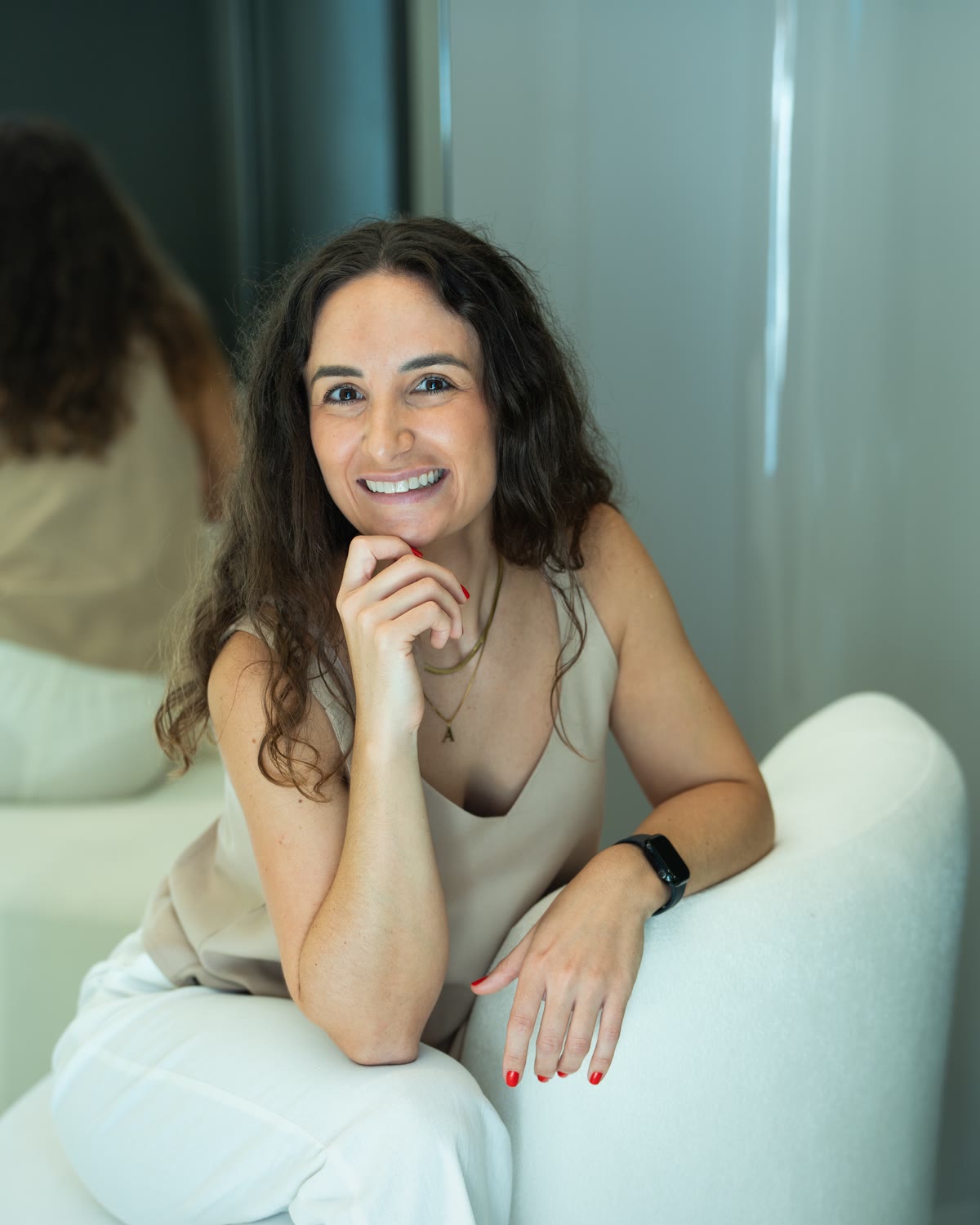 Dra. Ana Lucia Antonello sentada em uma poltrona clara, sorrindo